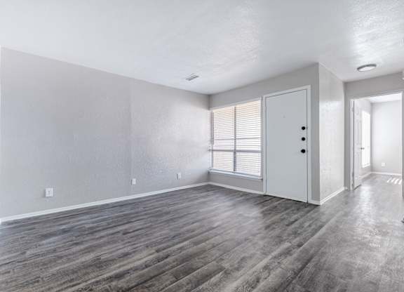 Empty living room with gray luxury vinyl flooring at Ridgeview Apartments, Texas, 75092