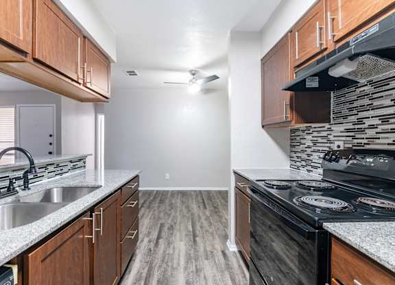 Kitchen with stainless sink and wood cabinetry at Ridgeview Apartments, Sherman