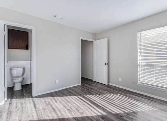 Unfurnished bedroom with private bathroom access at Ridgeview Apartments, Sherman, TX 75092