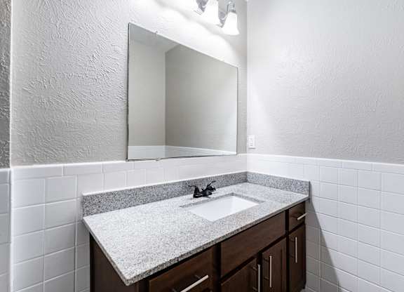 Bathroom vanity with subway tile surround at Ridgeview Apartments, Sherman, Texas