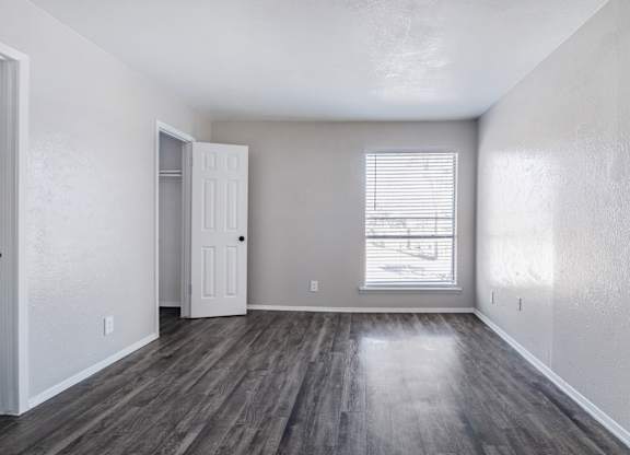 Empty bedroom with gray walls and vinyl flooring at Ridgeview Apartments, Sherman