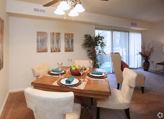 A dining room with a table set for a meal.