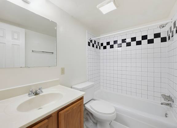 A white toilet sits next to a white sink in a bathroom.