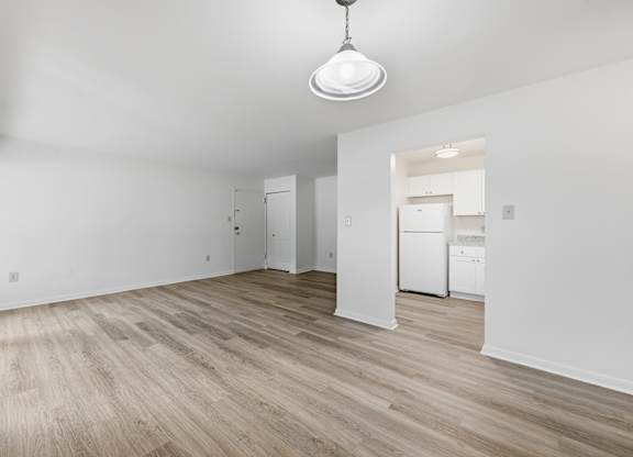 A room with wooden flooring and white walls.