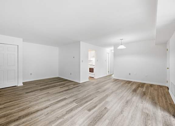 A room with wooden flooring and white walls.
