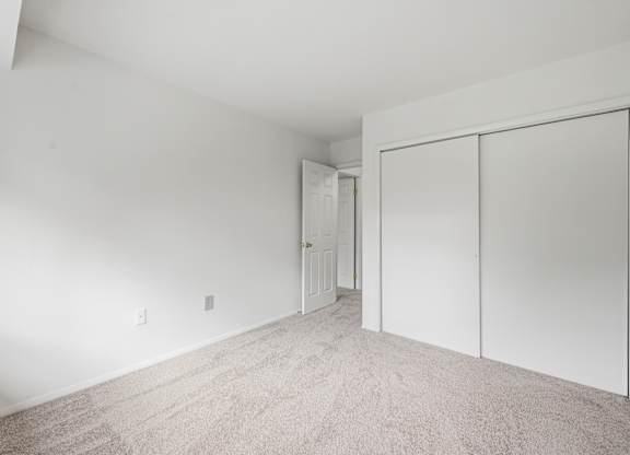 A room with a carpeted floor and white walls.