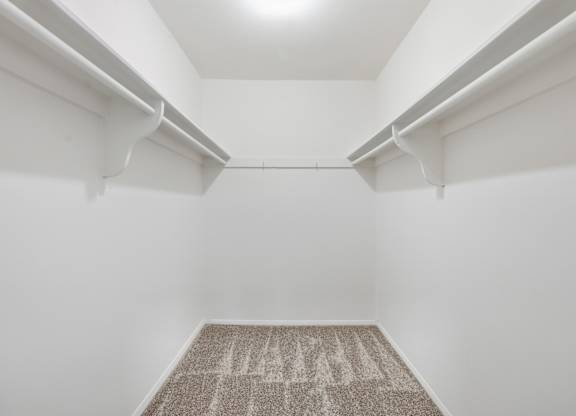 A hallway with a carpeted floor and white walls.