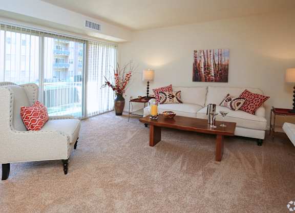 A living room with a white couch, a chair, and a coffee table.