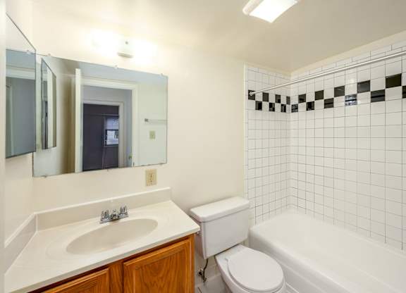 A white bathroom with a sink, toilet, and bathtub.