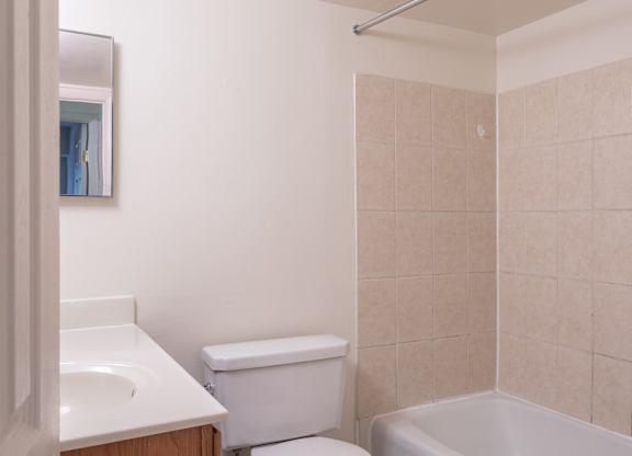 A white toilet sits next to a white sink in a bathroom.