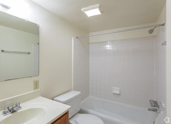 A white bathroom with a sink, toilet, and bathtub.