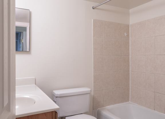 A white toilet sits next to a white sink in a bathroom.