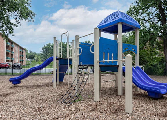 A playground with a blue slide and a blue and white structure.