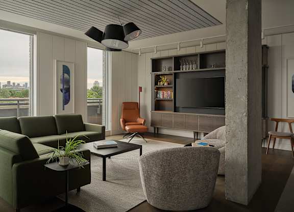 a living room with a couch and a chair and a television