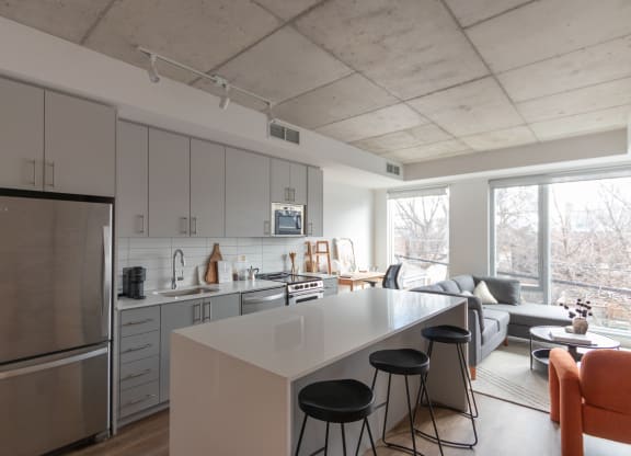 a kitchen and living room with a large island and stools