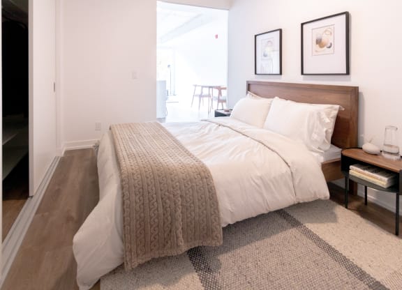 a bedroom with a bed and two pictures on the wall
