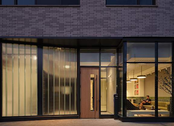 a man sitting on a couch in a lobby of a brick building