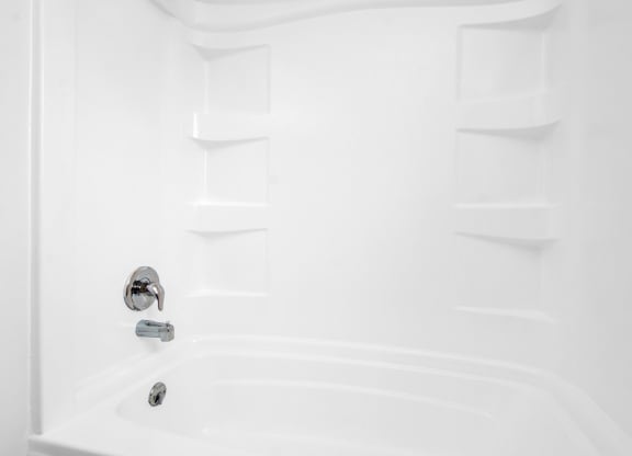a white bathroom with a shower and a sink