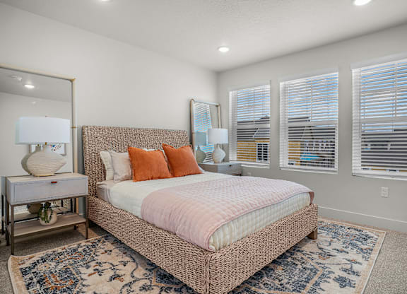 A bedroom with a large bed and a mirror on the wall.