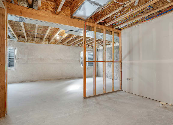 A room under construction with exposed wooden beams and unfinished walls.