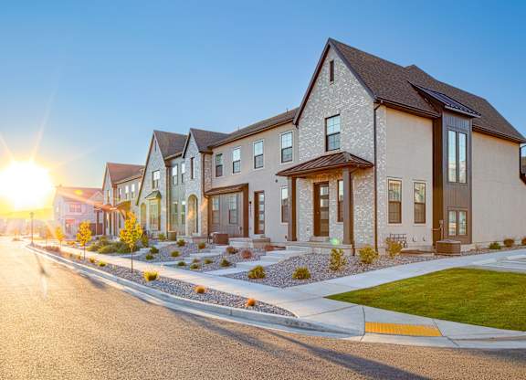 A row of houses with a sunset in the background.
