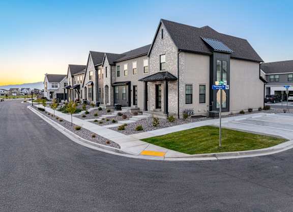 A row of houses with a street in front of them.