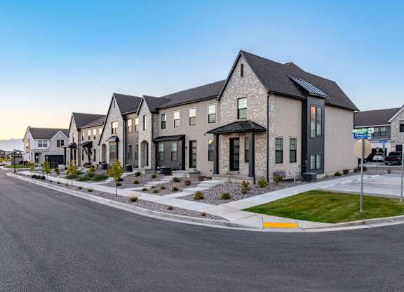 A row of modern houses with a clear blue sky above them.