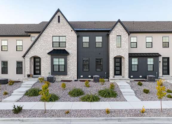 A row of houses with black front doors and windows.
