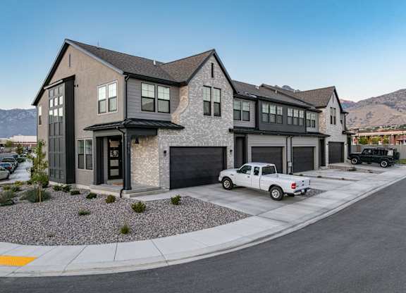 A modern house with a white pickup truck parked in front.