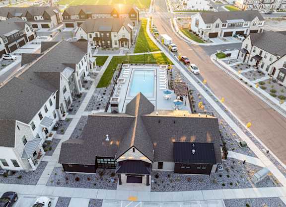 A bird's eye view of a residential area with houses and a swimming pool.