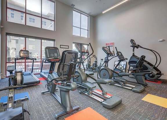 A gym with treadmills, elliptical machines, and other exercise equipment.
