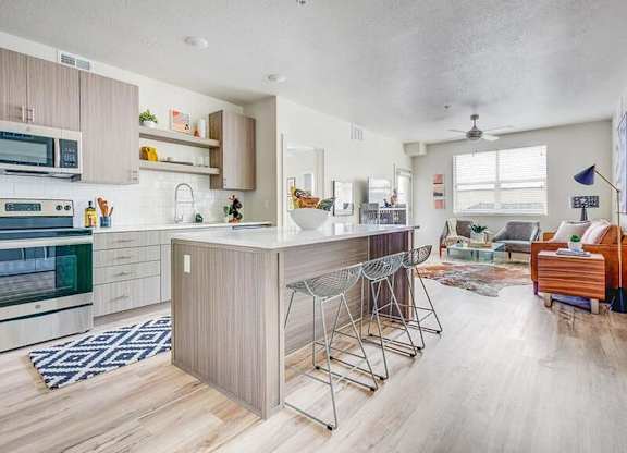 A kitchen with a bar stool and a dining table.