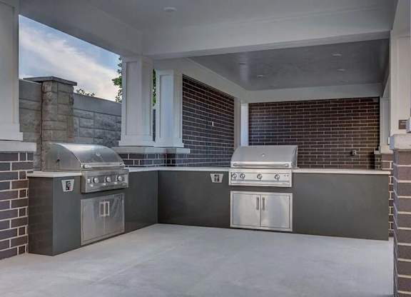 A modern outdoor kitchen with a grill and sink.