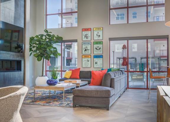 A living room with a couch, chair, and a potted plant.