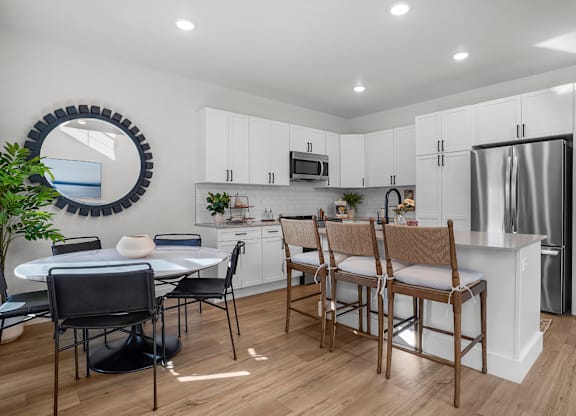 A modern kitchen with a dining table and chairs.
