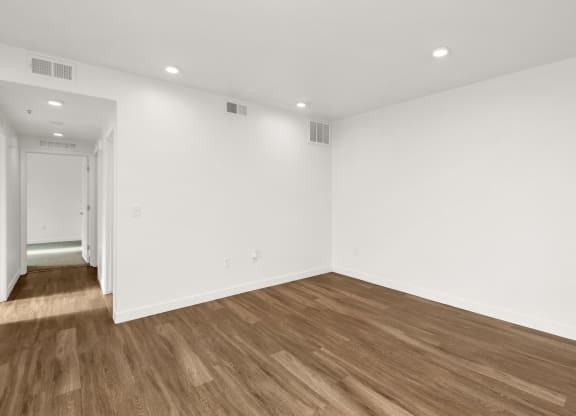 a living room with white walls and wood floors