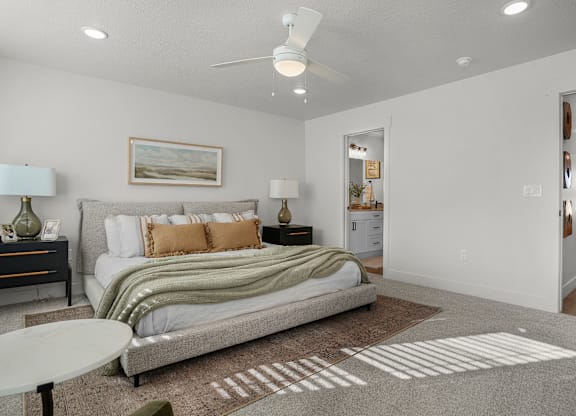 A bedroom with a bed, nightstands, and a ceiling fan.