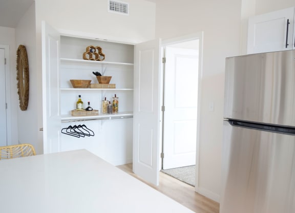 a kitchen with white walls and a stainless steel refrigerator