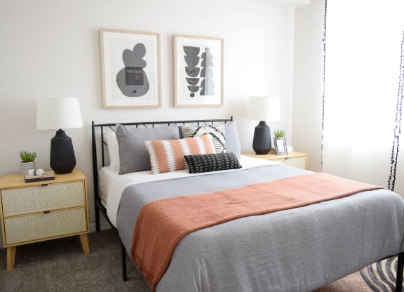 a bedroom with a bed and two night stands with lamps on them