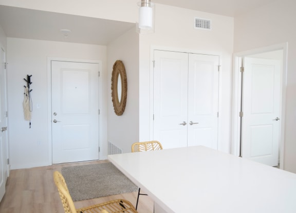 a dining room with a white table and yellow chairs