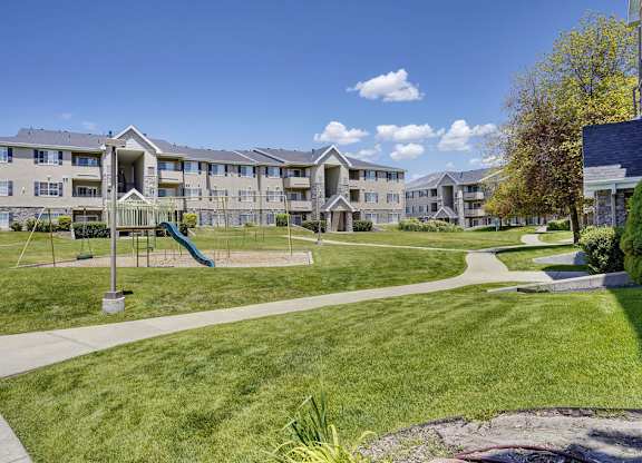 A large apartment complex with a playground in the front.