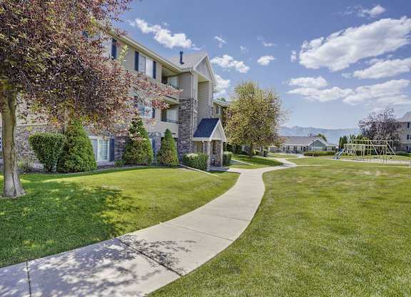 A residential area with apartment buildings and a well-maintained lawn.