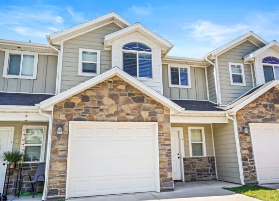 a beige house with two garage doors