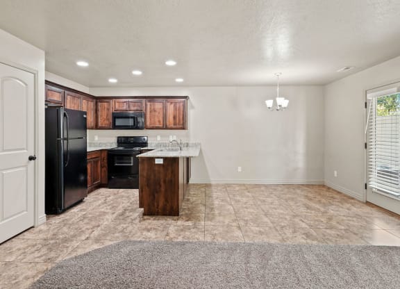 an empty kitchen with a refrigerator and a sink