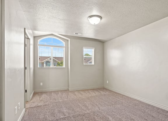 an empty living room with a window and a door