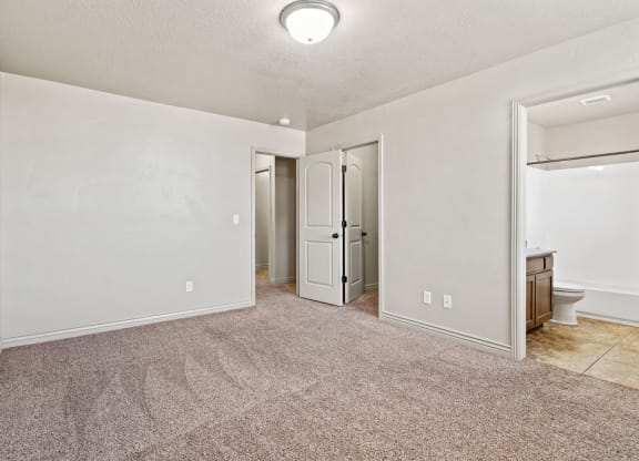 an empty living room with a door to the bathroom