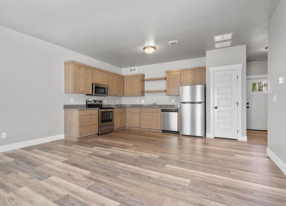 a kitchen with wooden cabinets and a stainless steel refrigerator