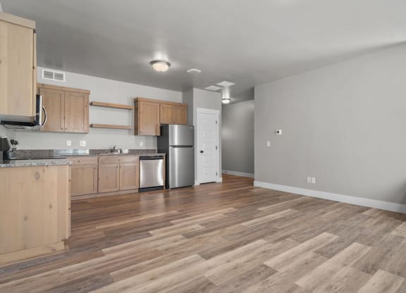 a kitchen with wooden floors and a stainless steel refrigerator