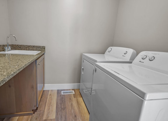 a laundry room with a sink and a washer and dryer