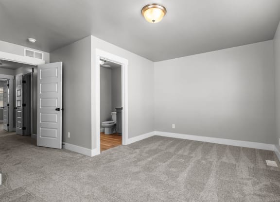 a bedroom with a closet and a door to a bathroom